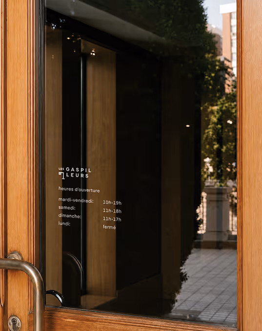credit chat gpt
mockup of storefront window for les gaspilleurs with opening hours