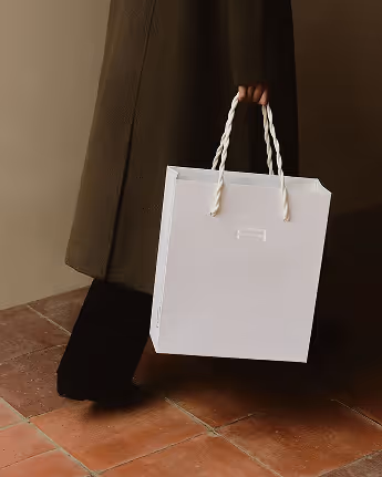 Credit: Emilia Piazza. Mockup of embossed logo Les Gaspilleurs white shopping bag.