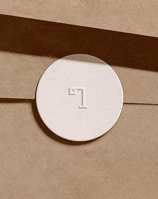 Credit Chat GPT
Rounded white sticker with the minimalist lamp logo embossed on the center, stuck on a brown paper