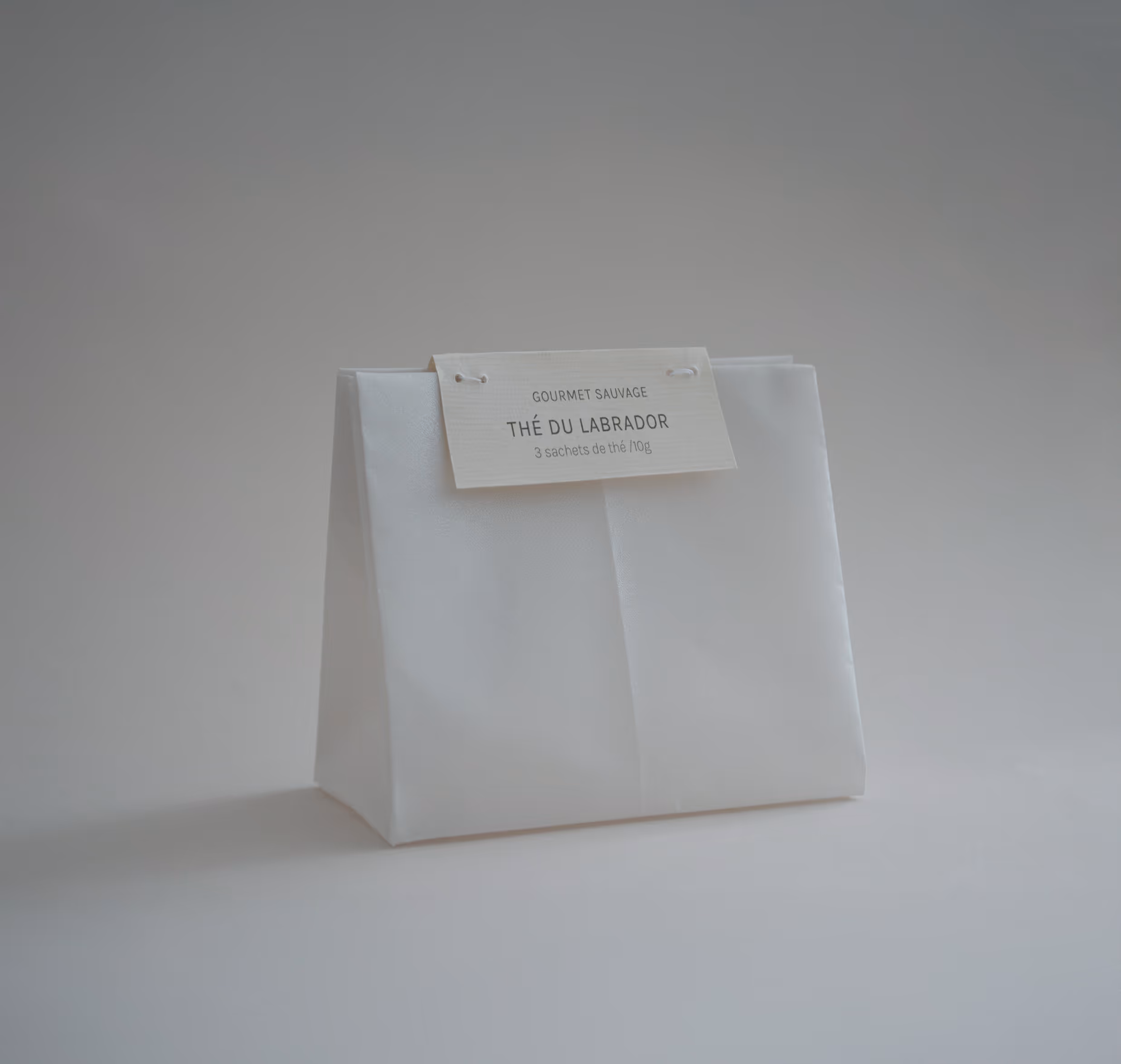 Credit: Emilia Piazza. White vellum paper Gourmet Sauvage tea package with label reading Thé du Labrador, containing three tea sachets.