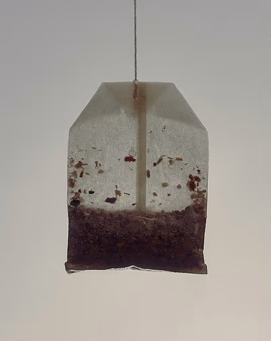 Credit: Death to Stock. Close-up of a tea bag with loose tea leaves inside against a plain background.